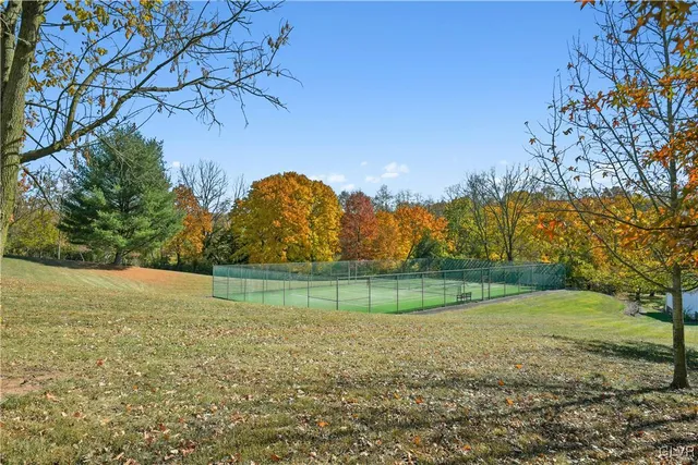 a view of a house with a yard and large trees