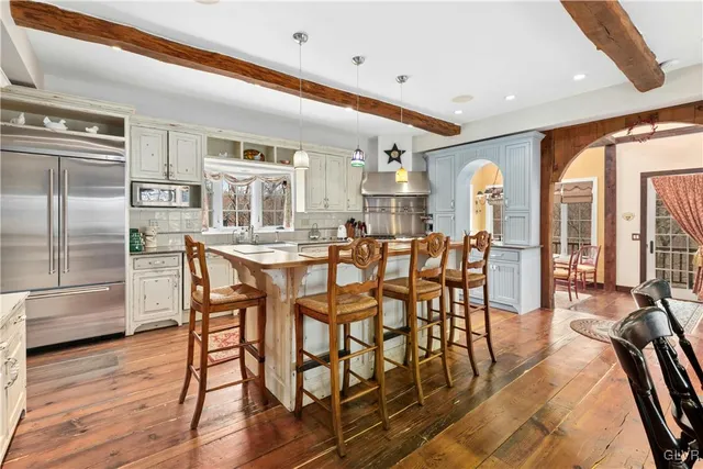 a large kitchen with stainless steel appliances granite countertop a stove and a dining table