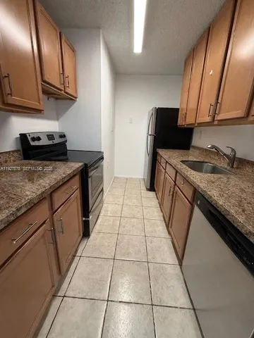 a kitchen with granite countertop stainless steel appliances and wooden cabinets