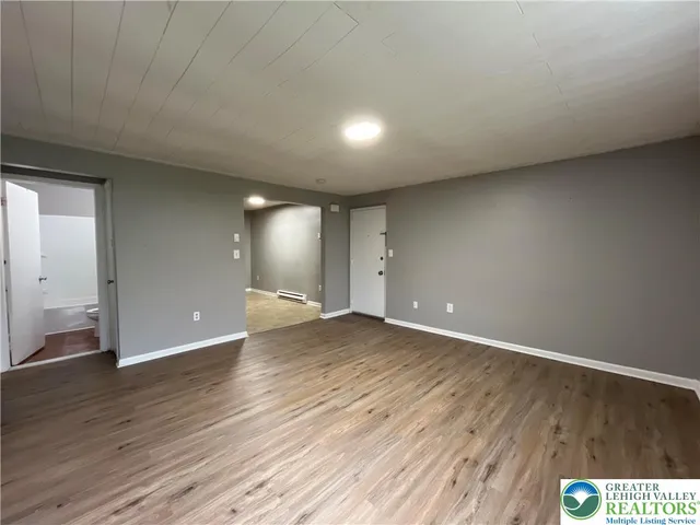 a view of an empty room with wooden floor