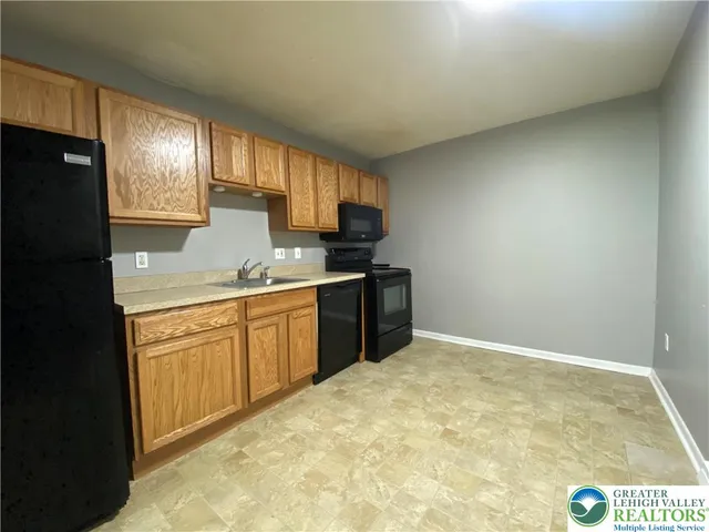 a kitchen with granite countertop a sink stainless steel appliances and cabinets