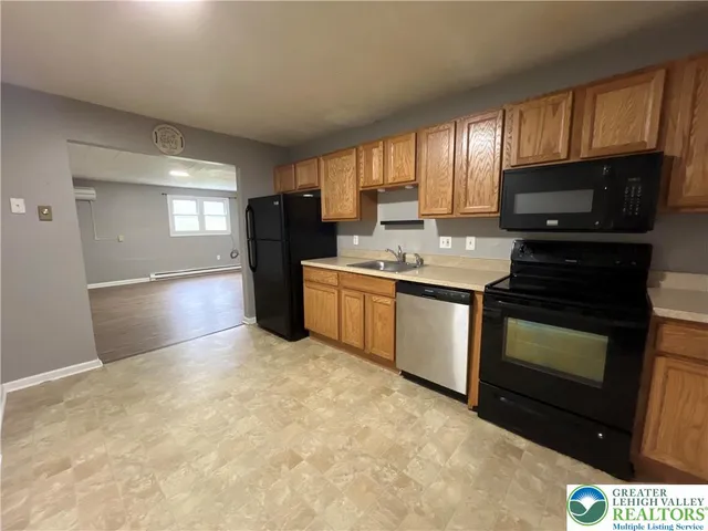 a kitchen with stainless steel appliances granite countertop a stove a sink dishwasher a refrigerator and a microwave oven