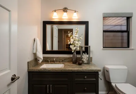 a bathroom with a granite countertop sink vanity and toilet
