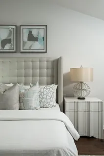 a bedroom with a bed and painting on the wall