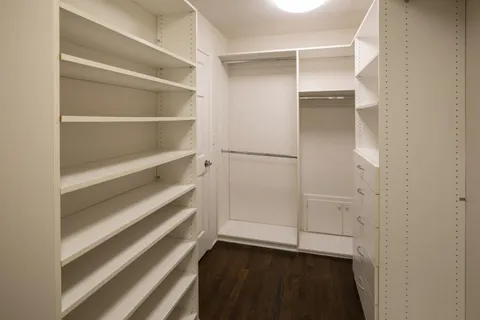 a view of walk in closet with empty racks