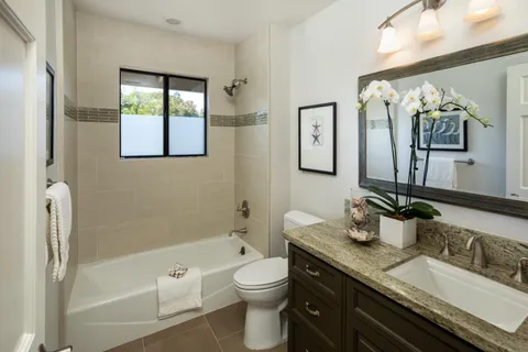 a bathroom with a granite countertop sink a toilet and shower