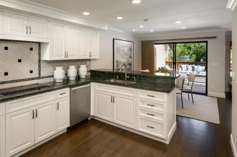a kitchen with granite countertop white cabinets and white appliances