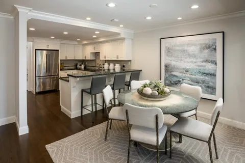 a kitchen with a dining table chairs and refrigerator