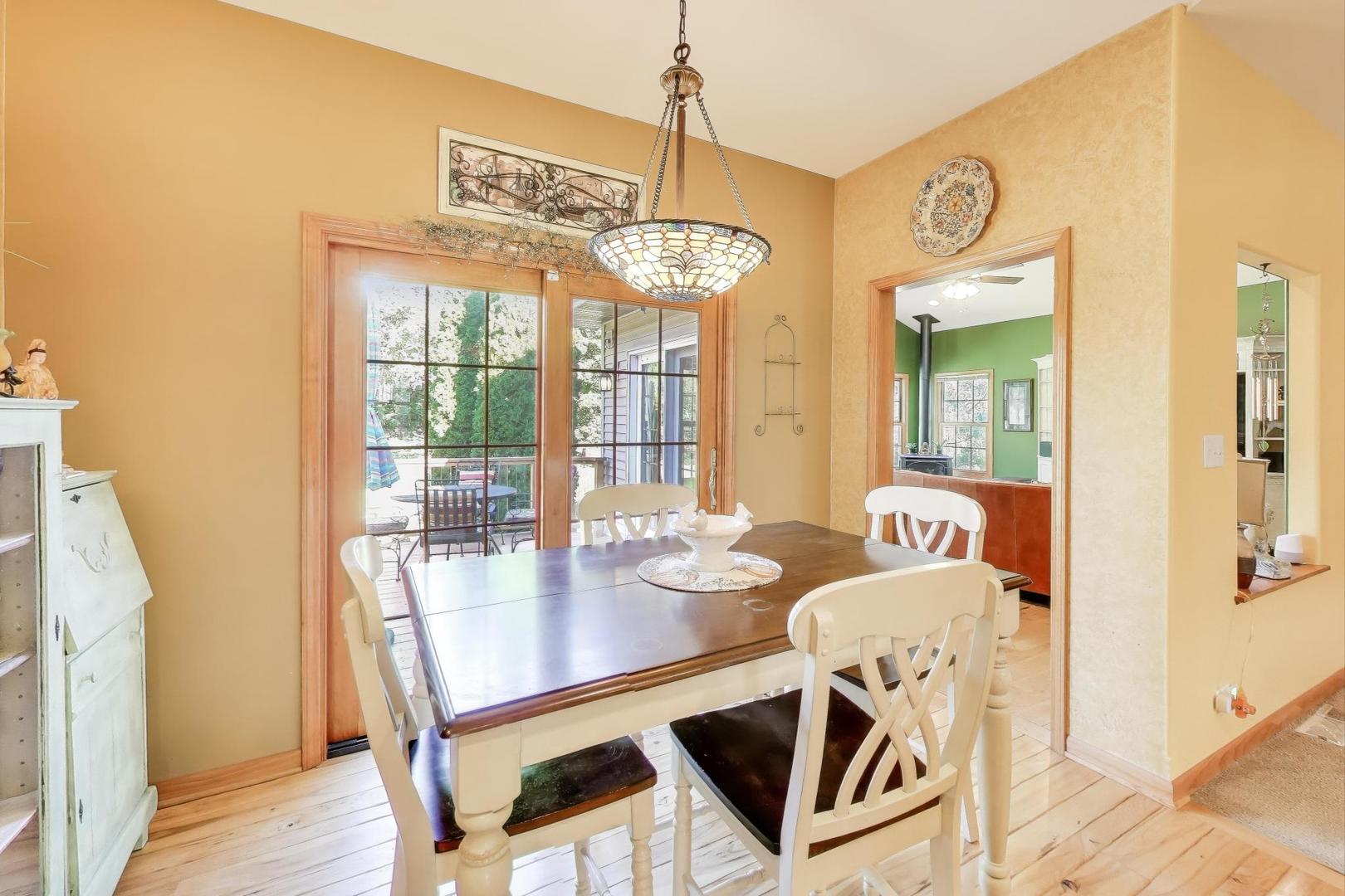 9206 Pine Needle Pass Bull Valley, IL 60097 - Photo 11 of 44 a view of a dining room with furniture wooden floor and a chandelier