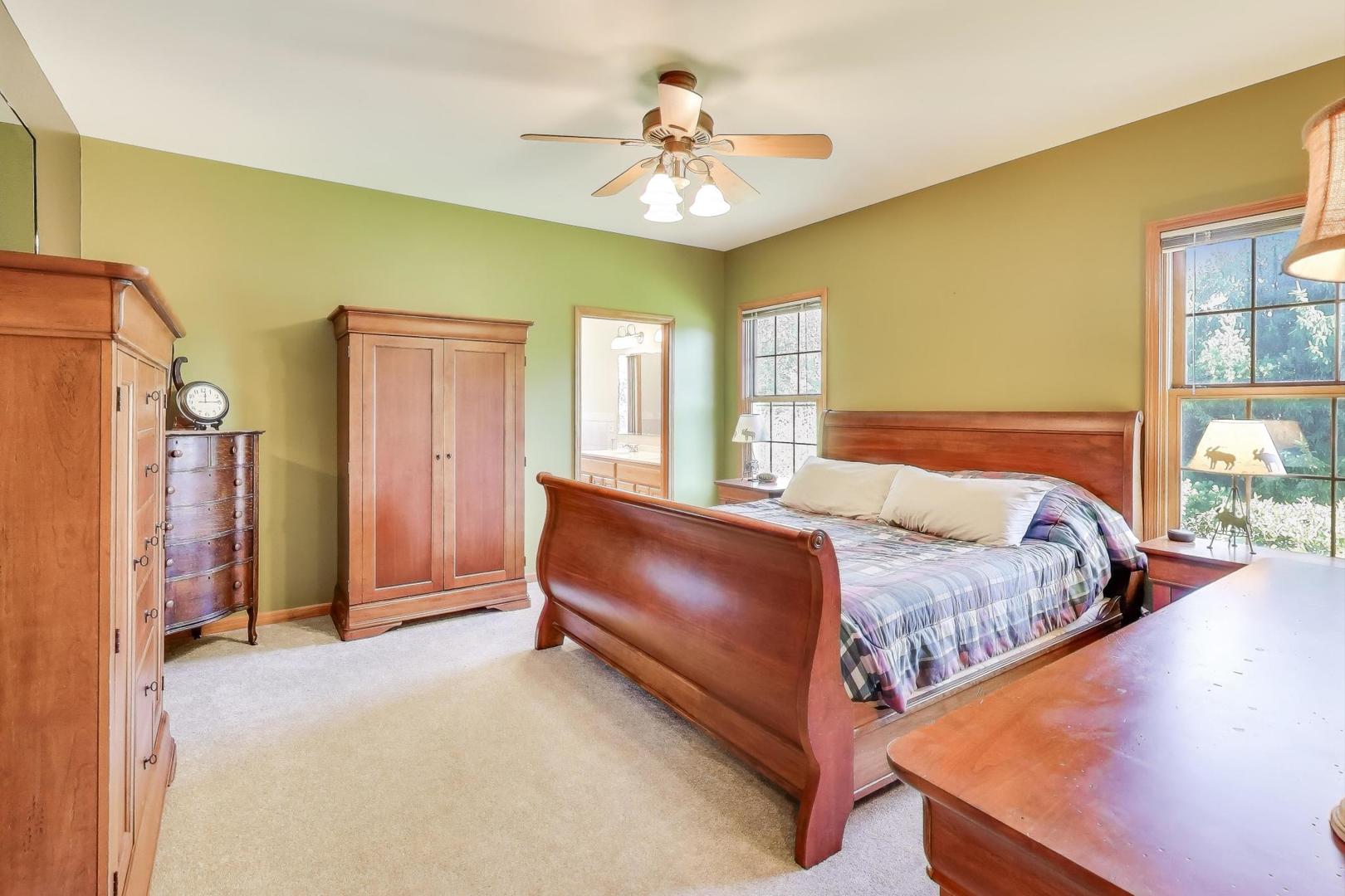 9206 Pine Needle Pass Bull Valley, IL 60097 - Photo 14 of 44 a bedroom with a bed and a chandelier