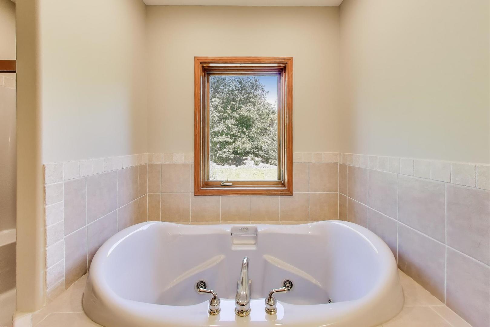9206 Pine Needle Pass Bull Valley, IL 60097 - Photo 16 of 44 a white bath tub sitting in a bathroom