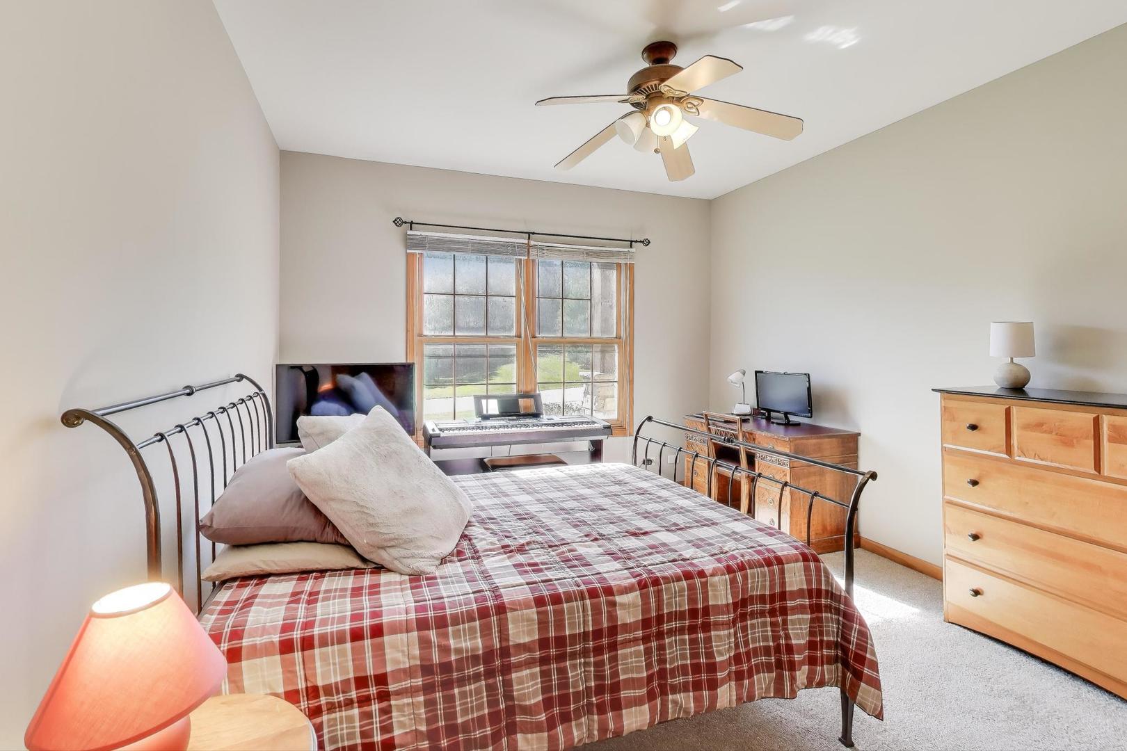 9206 Pine Needle Pass Bull Valley, IL 60097 - Photo 18 of 44 a bedroom with a bed and a chandelier