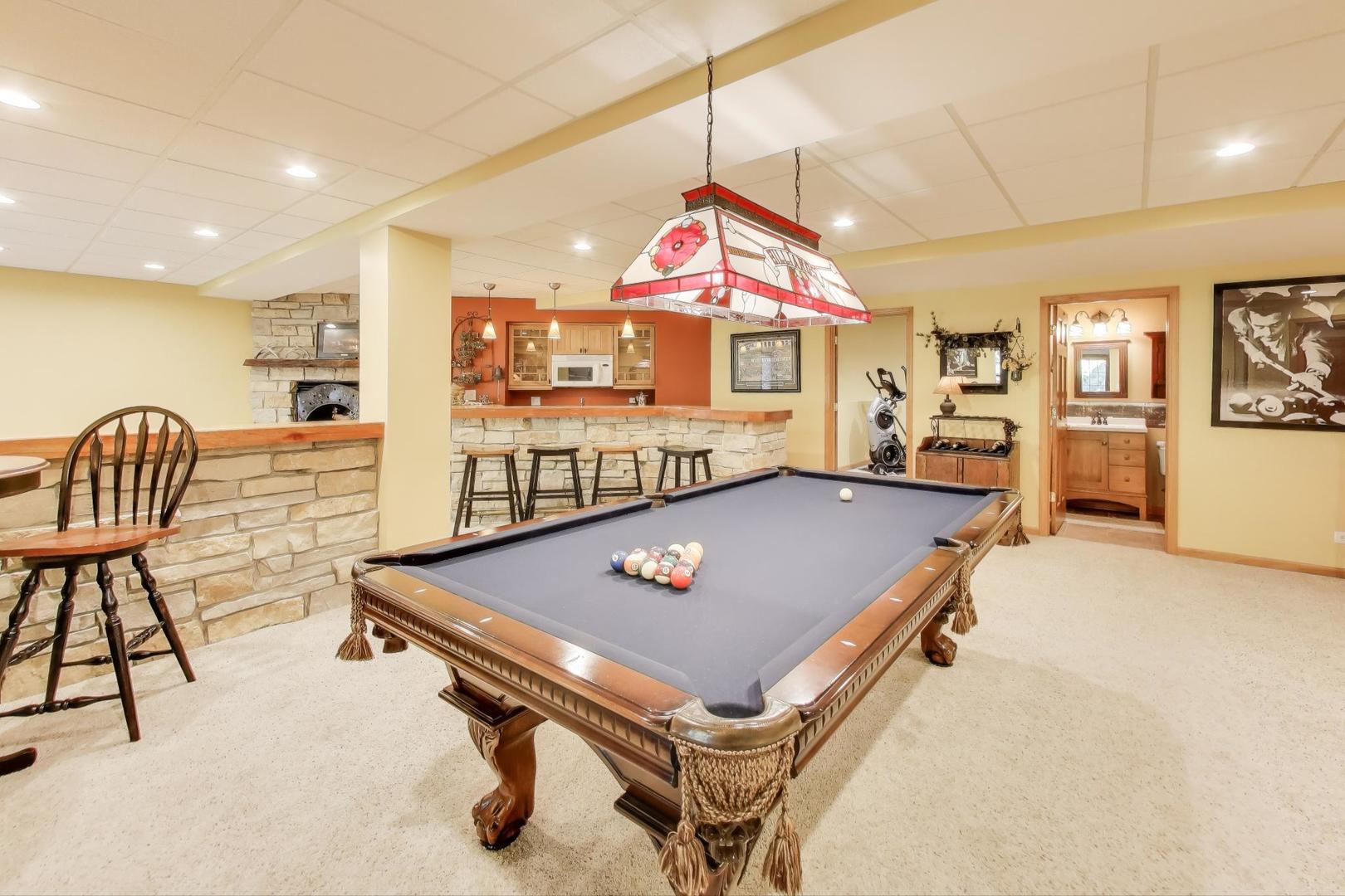 9206 Pine Needle Pass Bull Valley, IL 60097 - Photo 21 of 44 a living room with furniture pool table and a fireplace