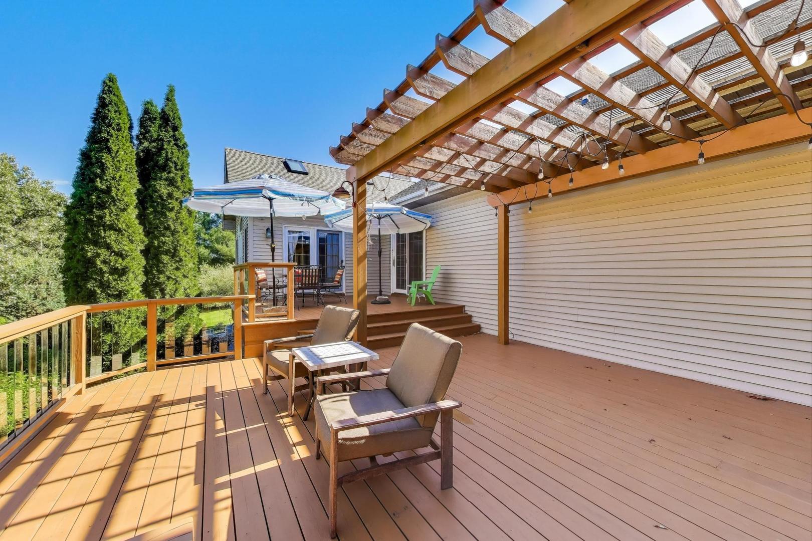 9206 Pine Needle Pass Bull Valley, IL 60097 - Photo 32 of 44 a view of a patio with table and chairs with wooden floor and fence