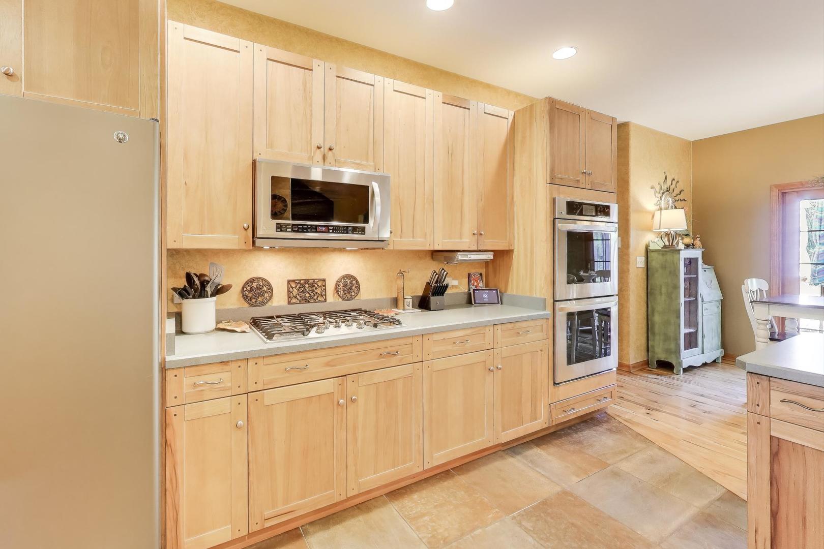 9206 Pine Needle Pass Bull Valley, IL 60097 - Photo 8 of 44 a kitchen with stainless steel appliances granite countertop a stove a sink and a microwave
