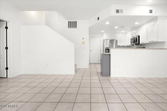 a view of a kitchen with white cabinets and refrigerator