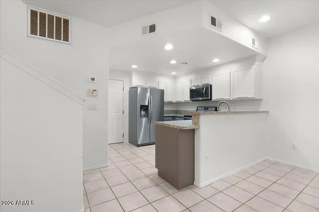 a kitchen with stainless steel appliances granite countertop a refrigerator and a sink