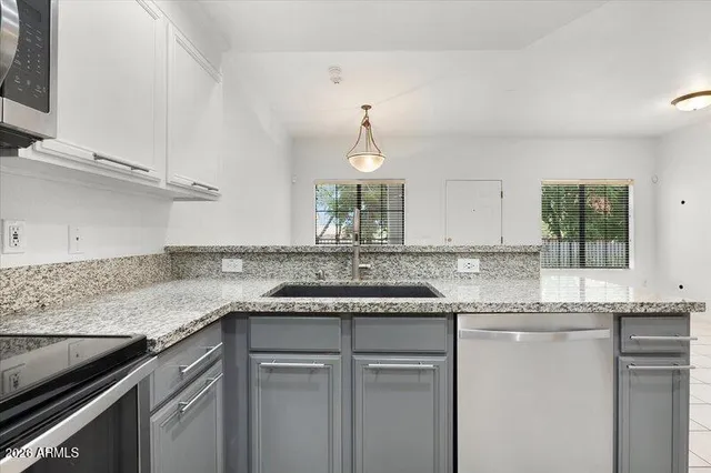 a kitchen with granite countertop a sink and cabinets