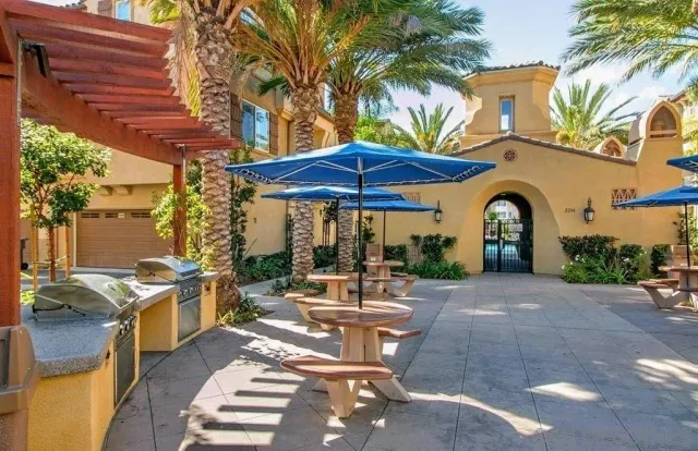 a patio with a table and chairs under an umbrella