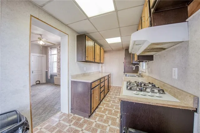 a kitchen with granite countertop a sink a stove and cabinets