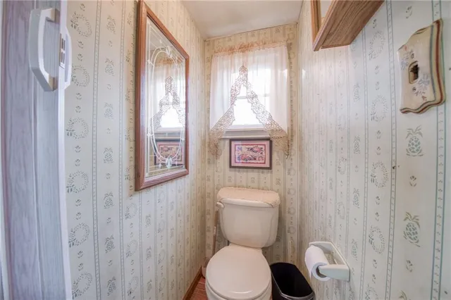 a white toilet sitting next to a shower curtain
