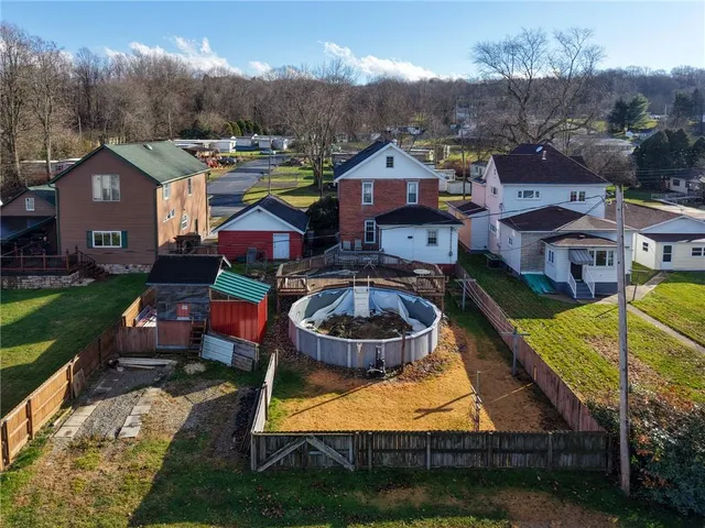 an aerial view of residential houses with yard and mountain view in back