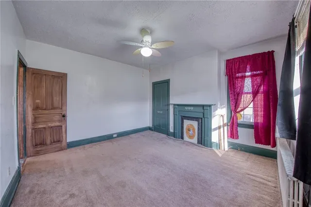 a view of empty room with fireplace and fan