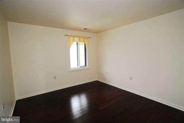 120 Cross Keys Road, Unit R120F Baltimore, MD 21210 - Photo 11 of 17 an empty room with wooden floor and windows