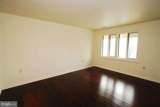 120 Cross Keys Road, Unit R120F Baltimore, MD 21210 - Photo 12 of 17 an empty room with wooden floor and windows
