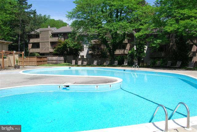 120 Cross Keys Road, Unit R120F Baltimore, MD 21210 - Photo 16 of 17 a view of a swimming pool with a lawn chairs and plants