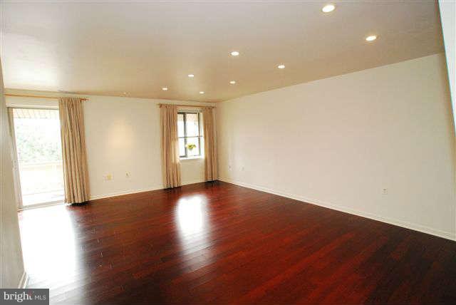 120 Cross Keys Road, Unit R120F Baltimore, MD 21210 - Photo 3 of 17 an empty room with wooden floor and windows with curtains