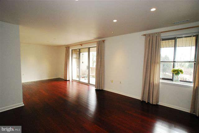 120 Cross Keys Road, Unit R120F Baltimore, MD 21210 - Photo 5 of 17 an empty room with wooden floor and windows