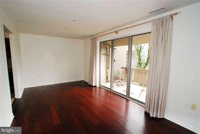 120 Cross Keys Road, Unit R120F Baltimore, MD 21210 - Photo 6 of 17 a view of an empty room with wooden floor and a window