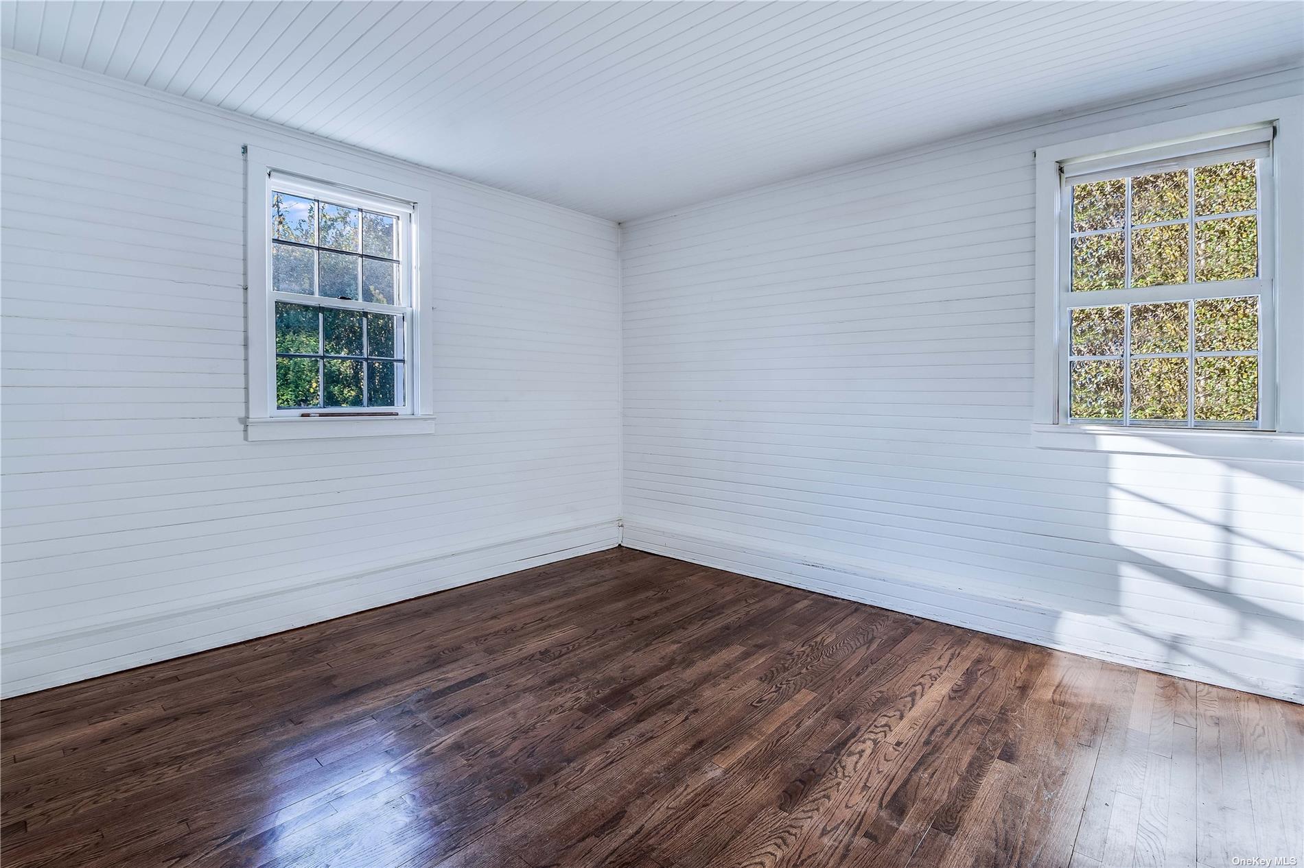 88 Pantigo Road East Hampton, NY 11937 - Photo 17 of 18 a view of an empty room with wooden floor and a window
