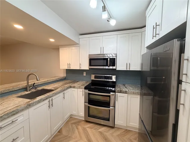 a kitchen with a sink stainless steel appliances and cabinets