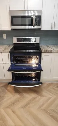 a stove top oven sitting inside of a kitchen