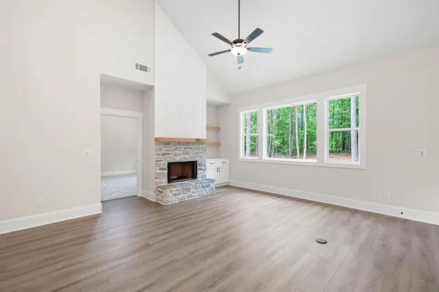 an empty room with a window and ceiling fan