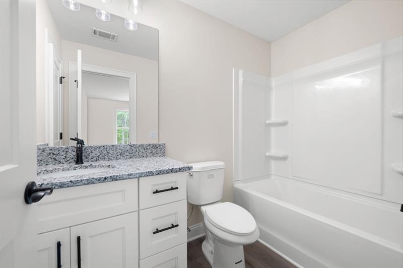 110 Doris Path Temple, GA 30179 - Photo 29 of 35 a bathroom with a granite countertop toilet a sink and a bathtub