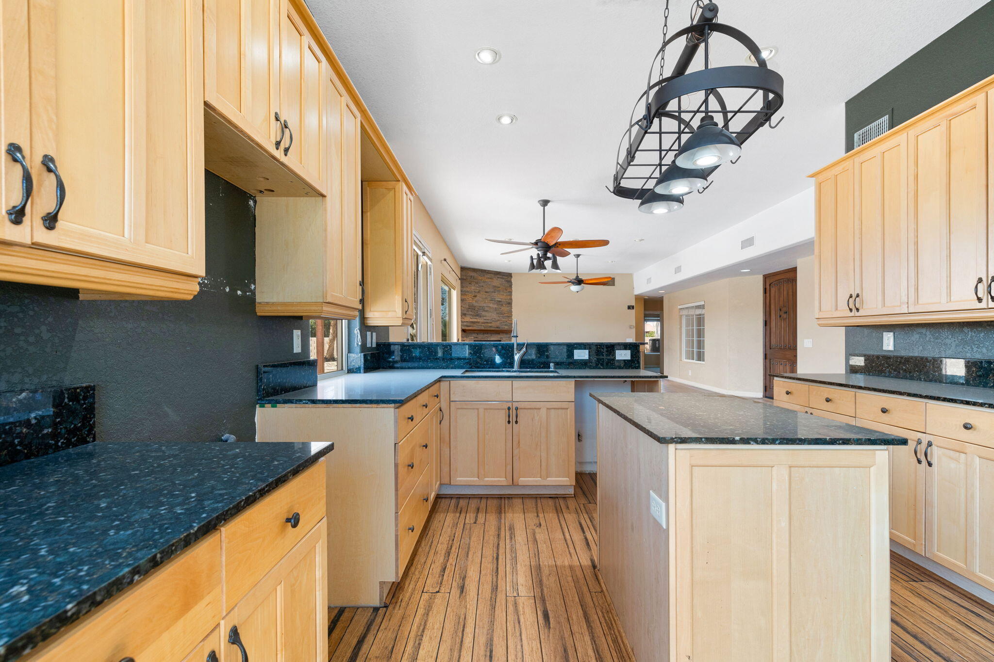 48755 Southview Place Indio, CA 92201 - Photo 26 of 55 a kitchen with a sink dishwasher a stove a microwave oven with cabinets and wooden floor