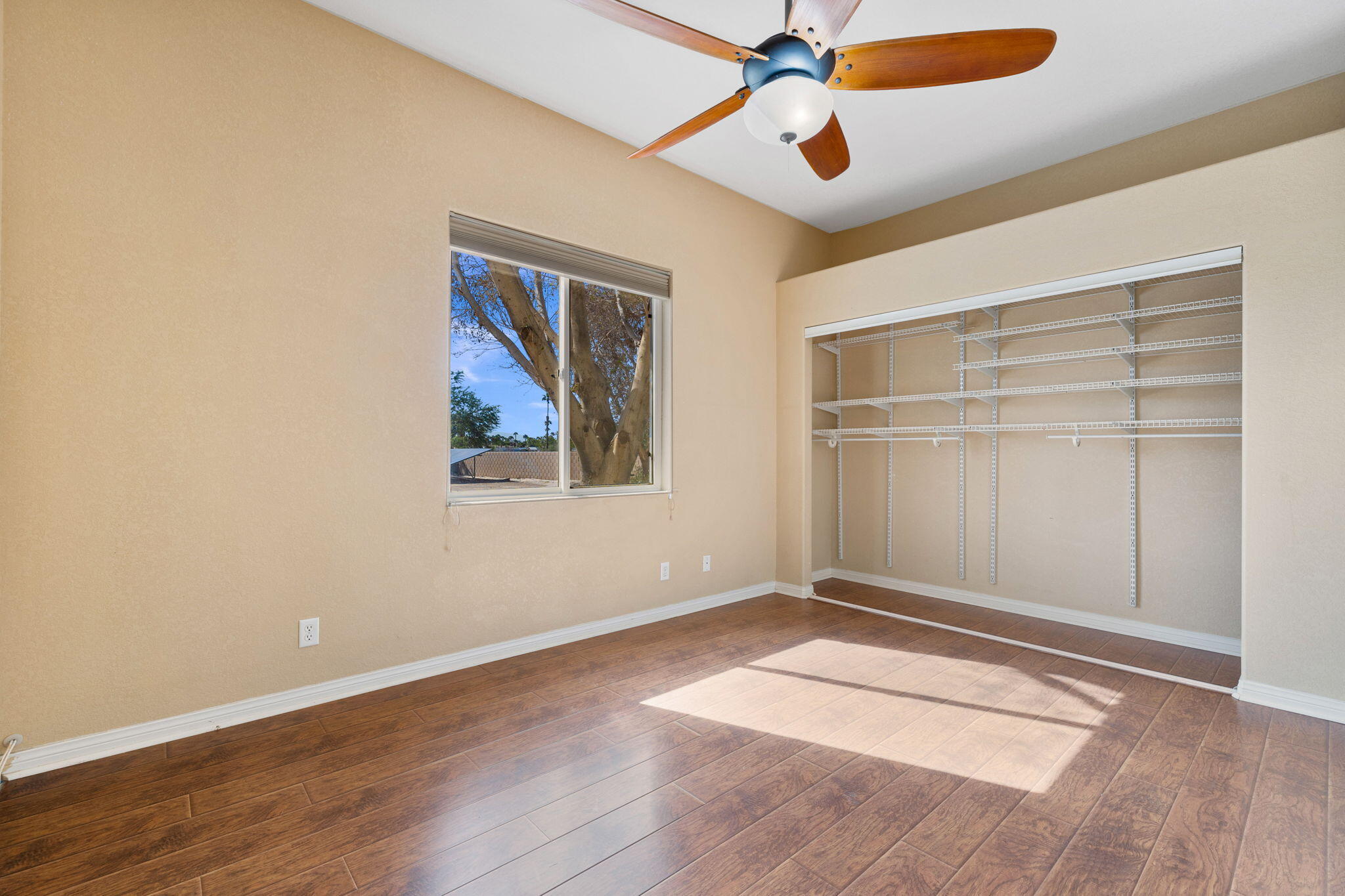 48755 Southview Place Indio, CA 92201 - Photo 34 of 55 an empty room with wooden floor chandelier fan and windows
