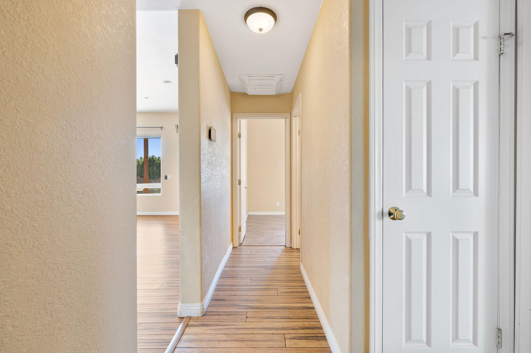 48755 Southview Place Indio, CA 92201 - Photo 37 of 55 a view of a hallway with wooden floor and a bathroom