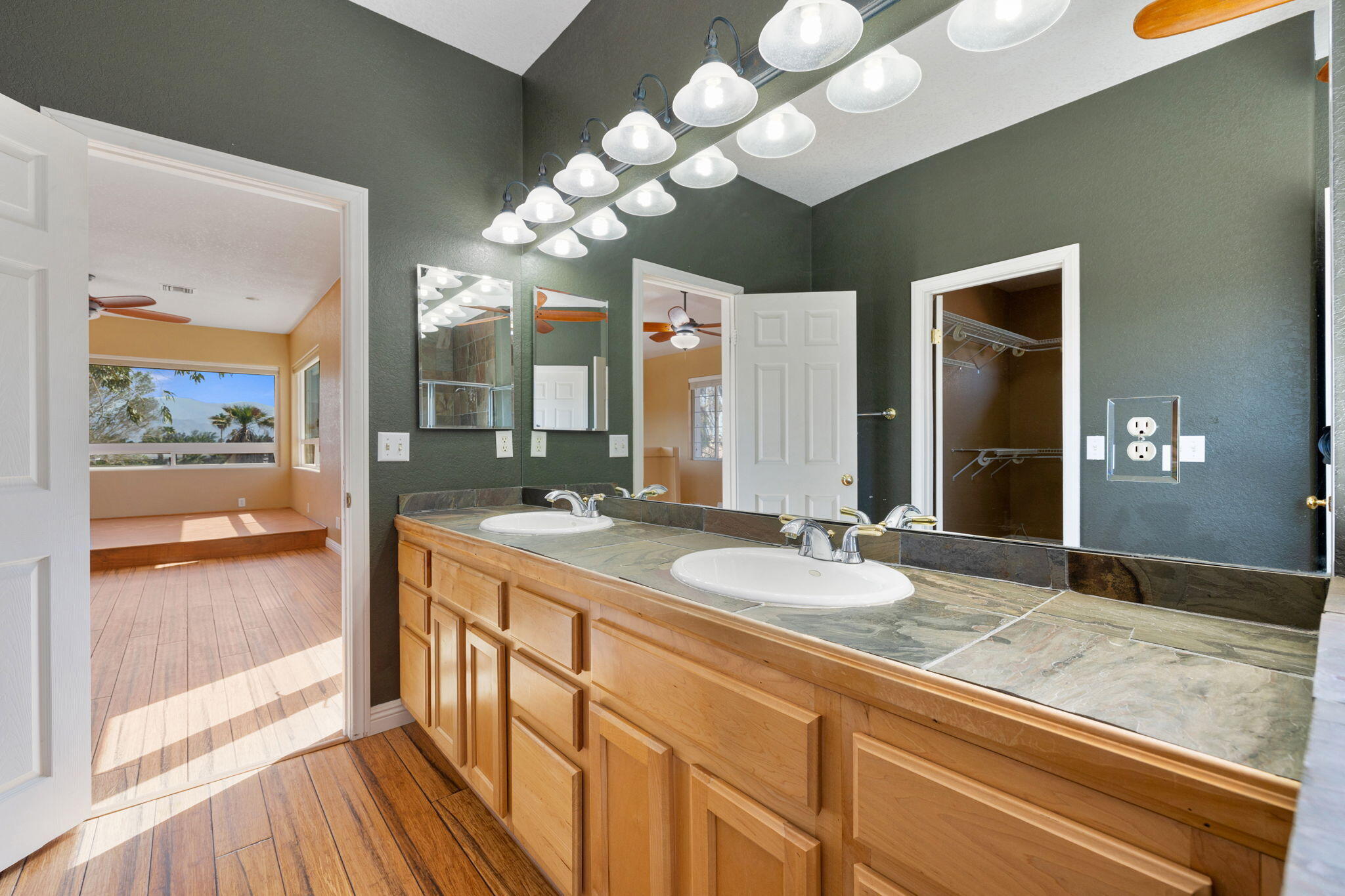 48755 Southview Place Indio, CA 92201 - Photo 49 of 55 a spacious bathroom with a granite countertop sink a large mirror and a shower