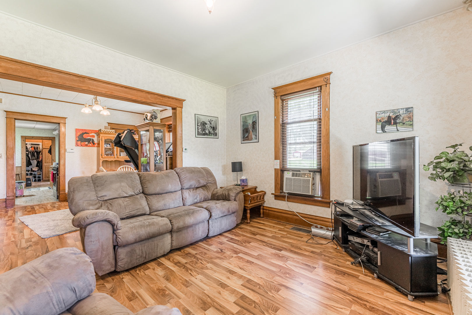 12757 Base Line Road Genoa, IL 60135 - Photo 11 of 49 a living room with furniture a flat screen tv and a floor to ceiling window