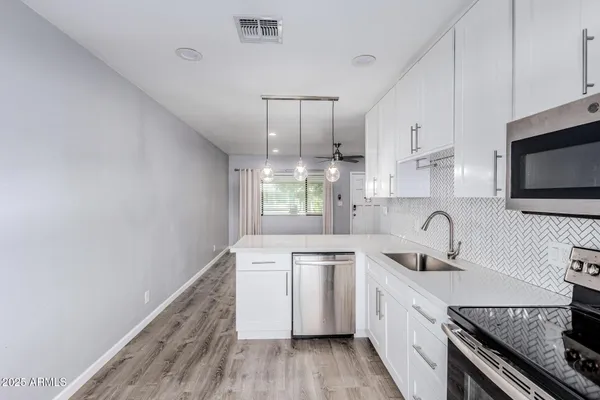 a kitchen that has a sink and a stove top oven