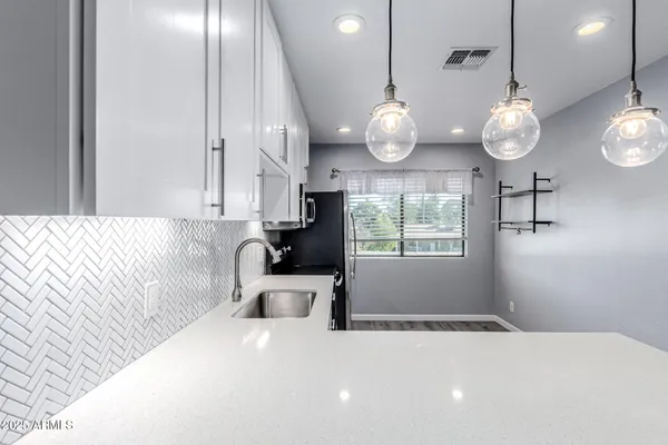 a large white kitchen with a large window cabinets and stainless steel appliances