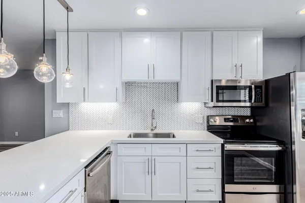 a kitchen with a sink and stainless steel appliances