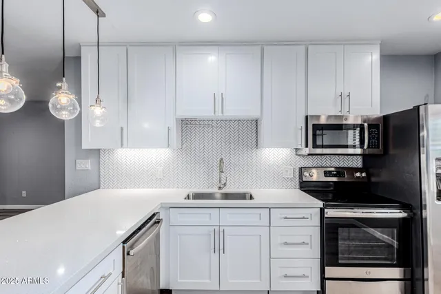 a kitchen with a sink and stainless steel appliances