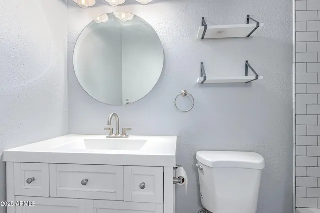 a bathroom with a sink mirror and toilet