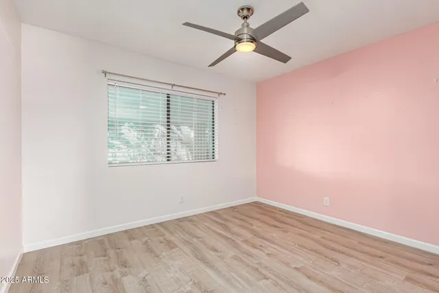 an empty room with a window and a fan