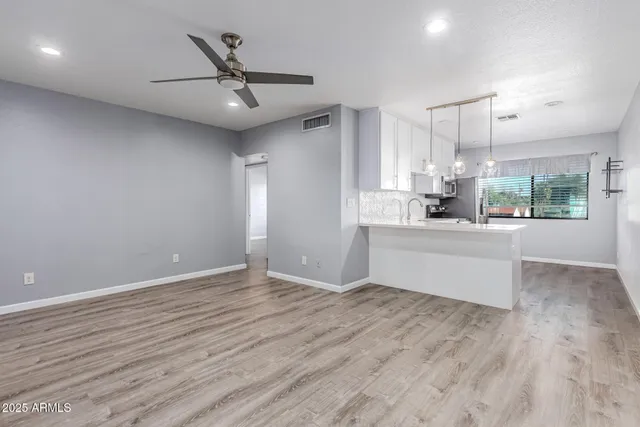 a view of a kitchen with a sink and dishwasher a refrigerator with wooden floor